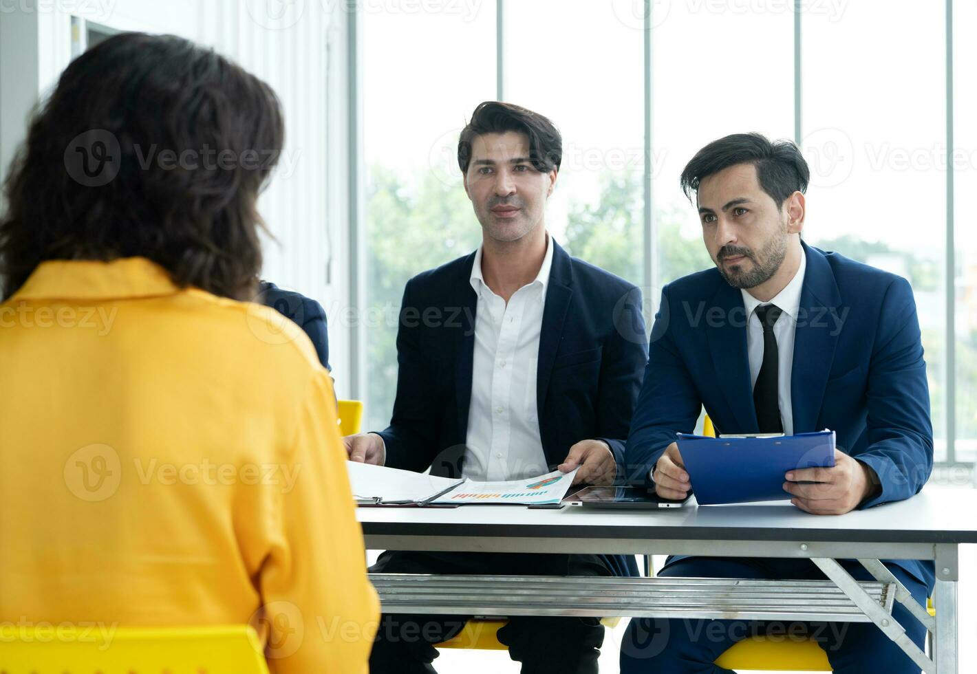 Job interview concept. Diverse hr team doing job interview with a woman in business office. Human resources team interviewing a potential job candidate. Hiring, employment, and recruitment concept. photo