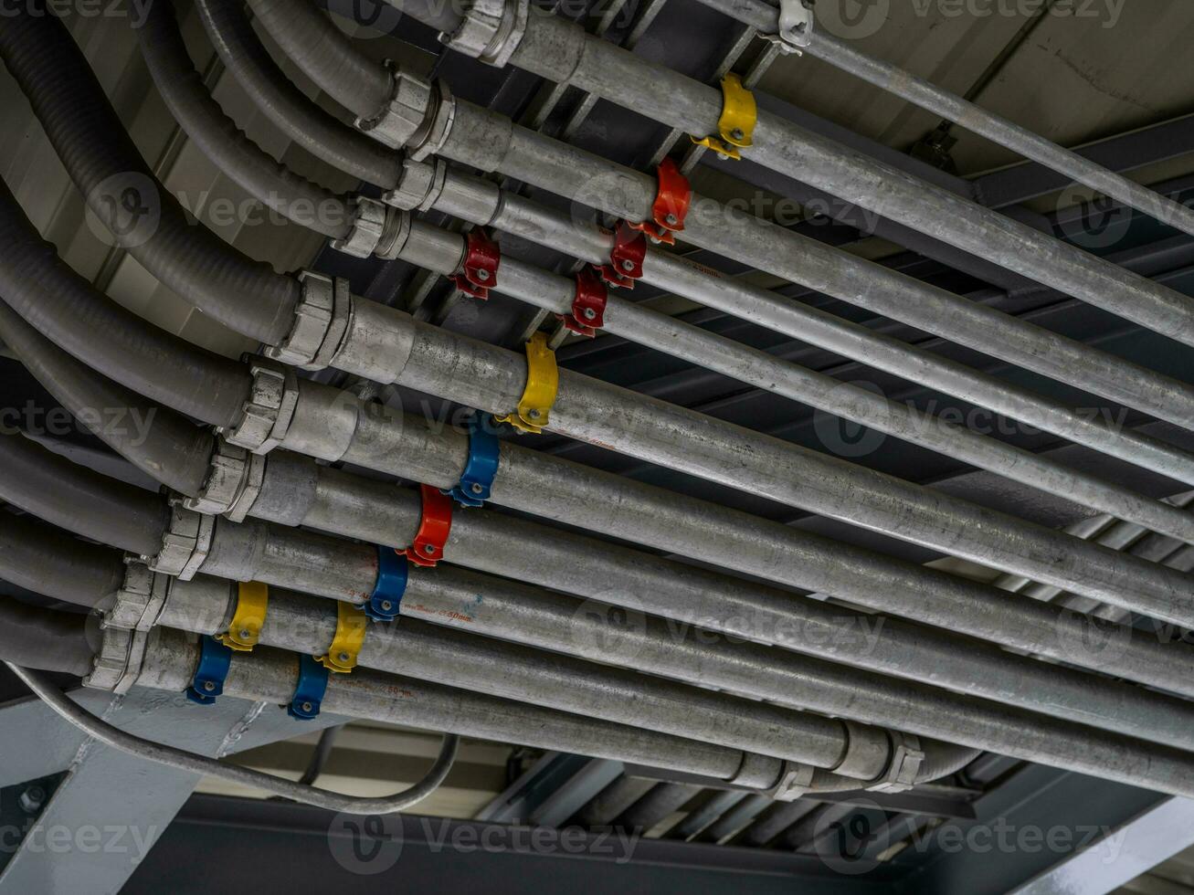 Electrical conduit system and tube of electric cable installed on building ceiling. Industrial infrastructure. Efficient electrical wiring installation and management. Wiring and conduit system. photo
