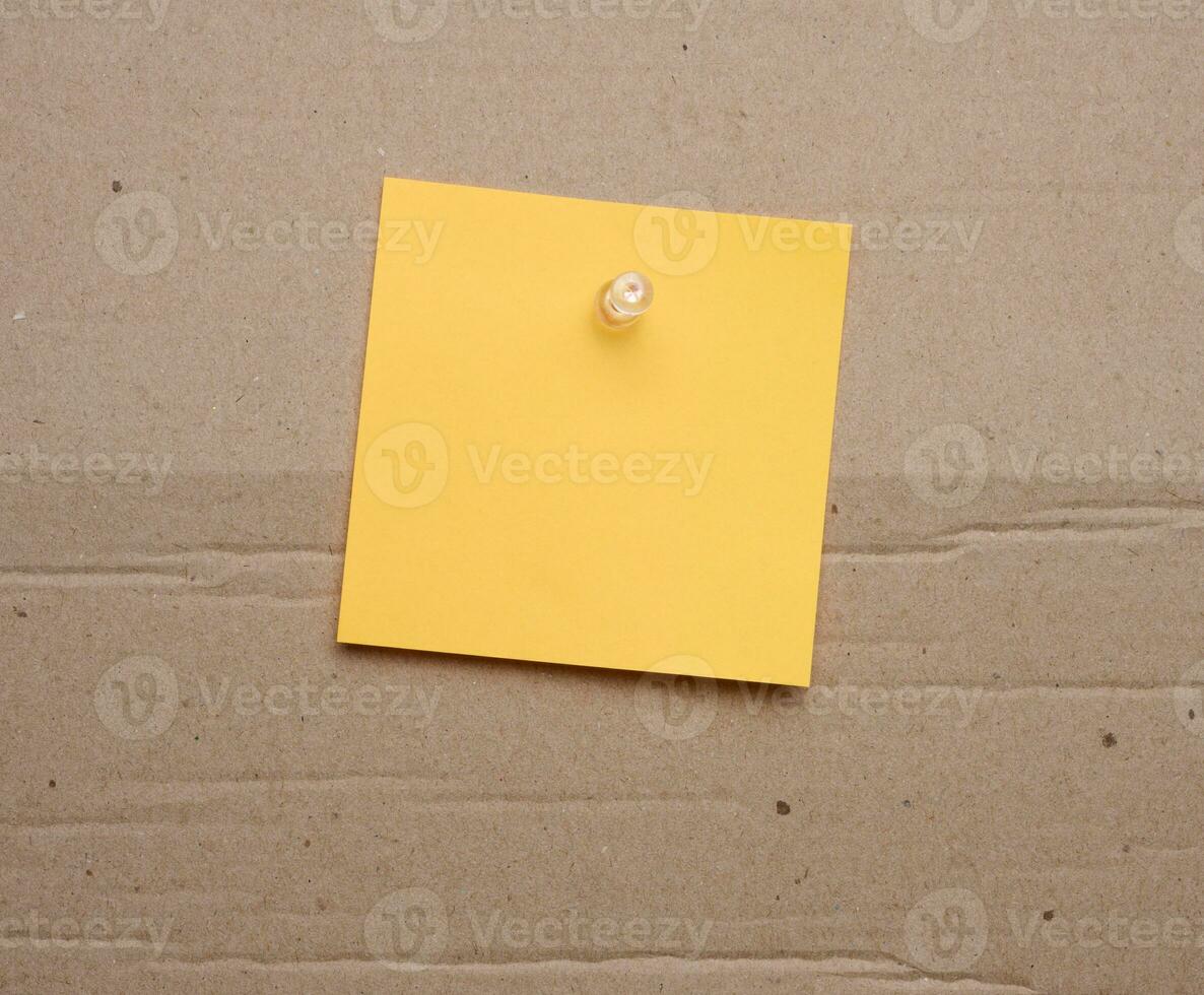 Yellow paper blank stickers attached with a button, space for notes and labels photo