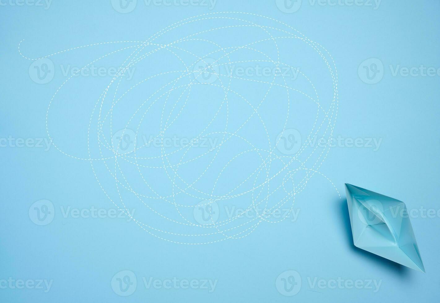 A blue paper boat and a long tangled path, symbolizing the concept of a challenging journey photo