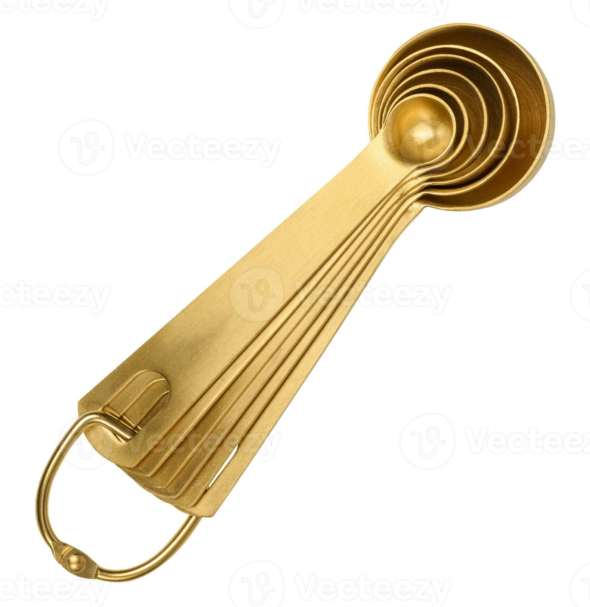 Golden metal measuring spoons for bulk and liquid products on a white