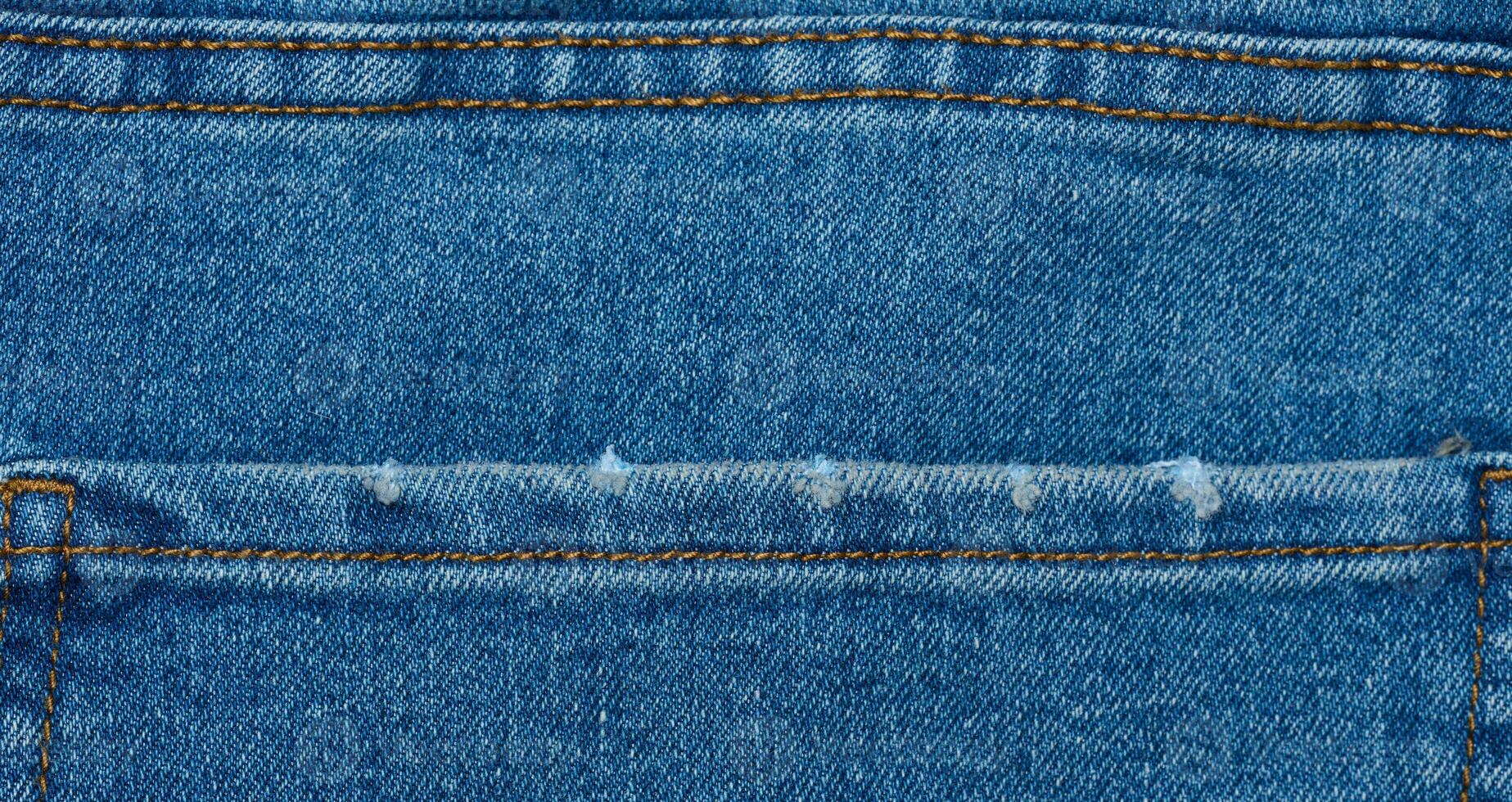 Fragment of the back pocket of blue jeans photo