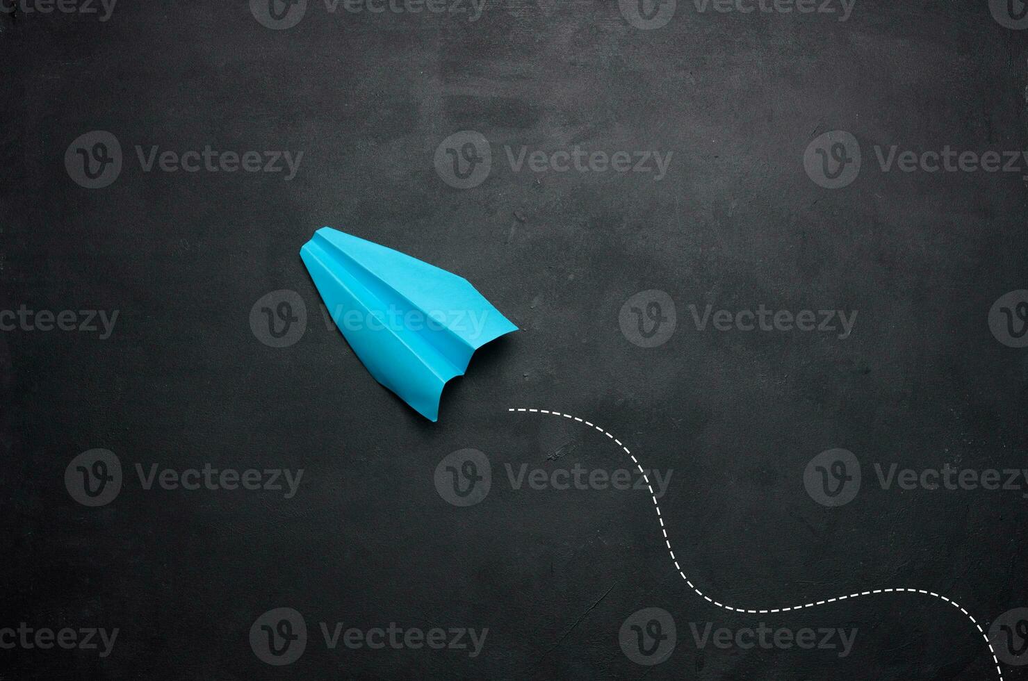 Blue paper airplane on a black background, travel concept, top view. Copy space photo