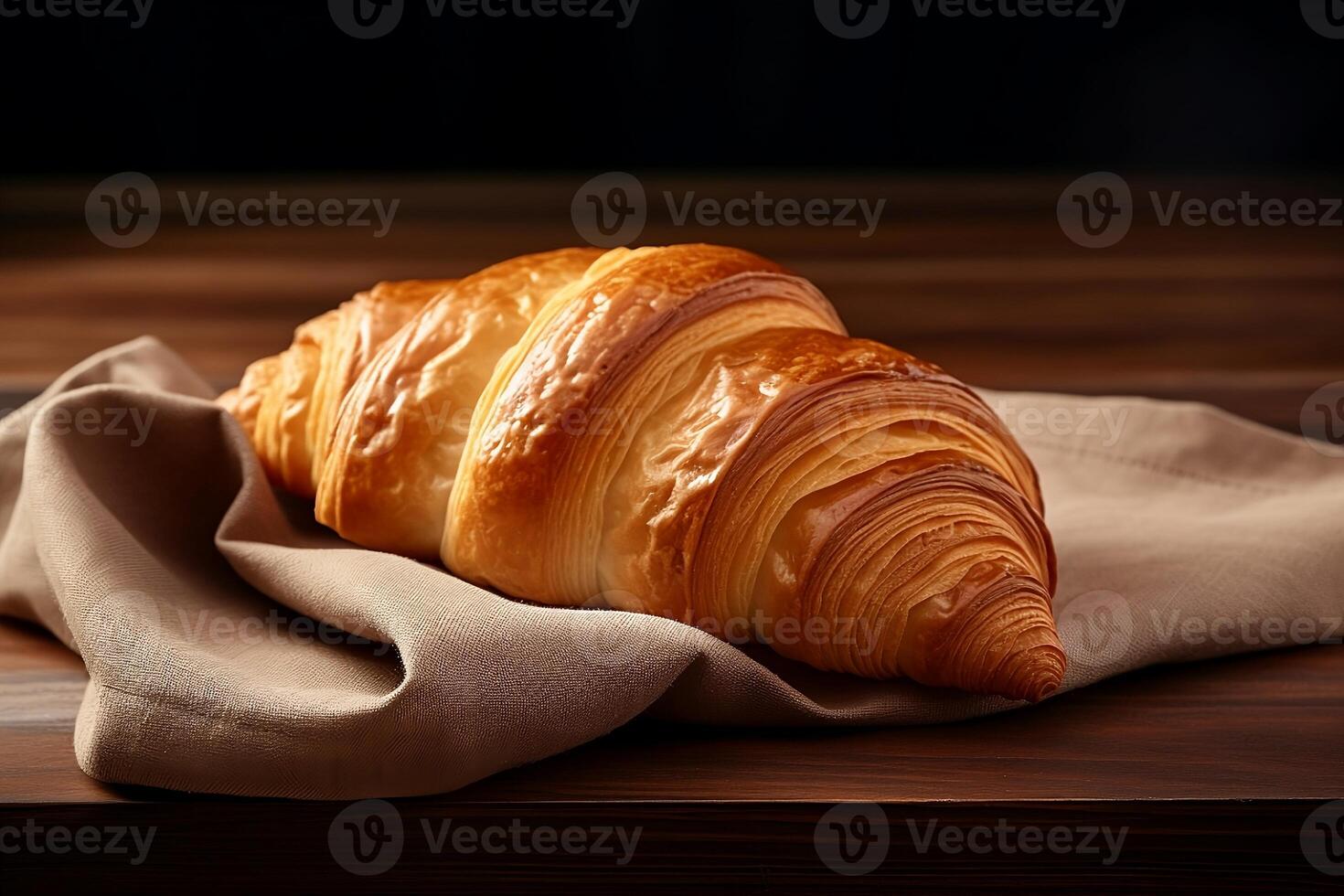 A crispy croissant is lying and a towel. photo