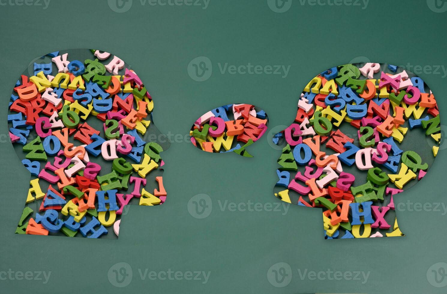 Two silhouettes of human heads with colorful letters, concept of conversation, intellectual discussion photo