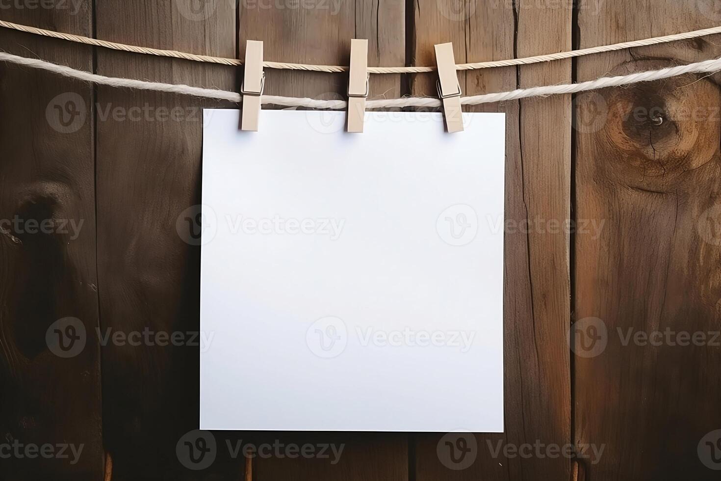 White paper sheets hang on a string with a clothespin. photo