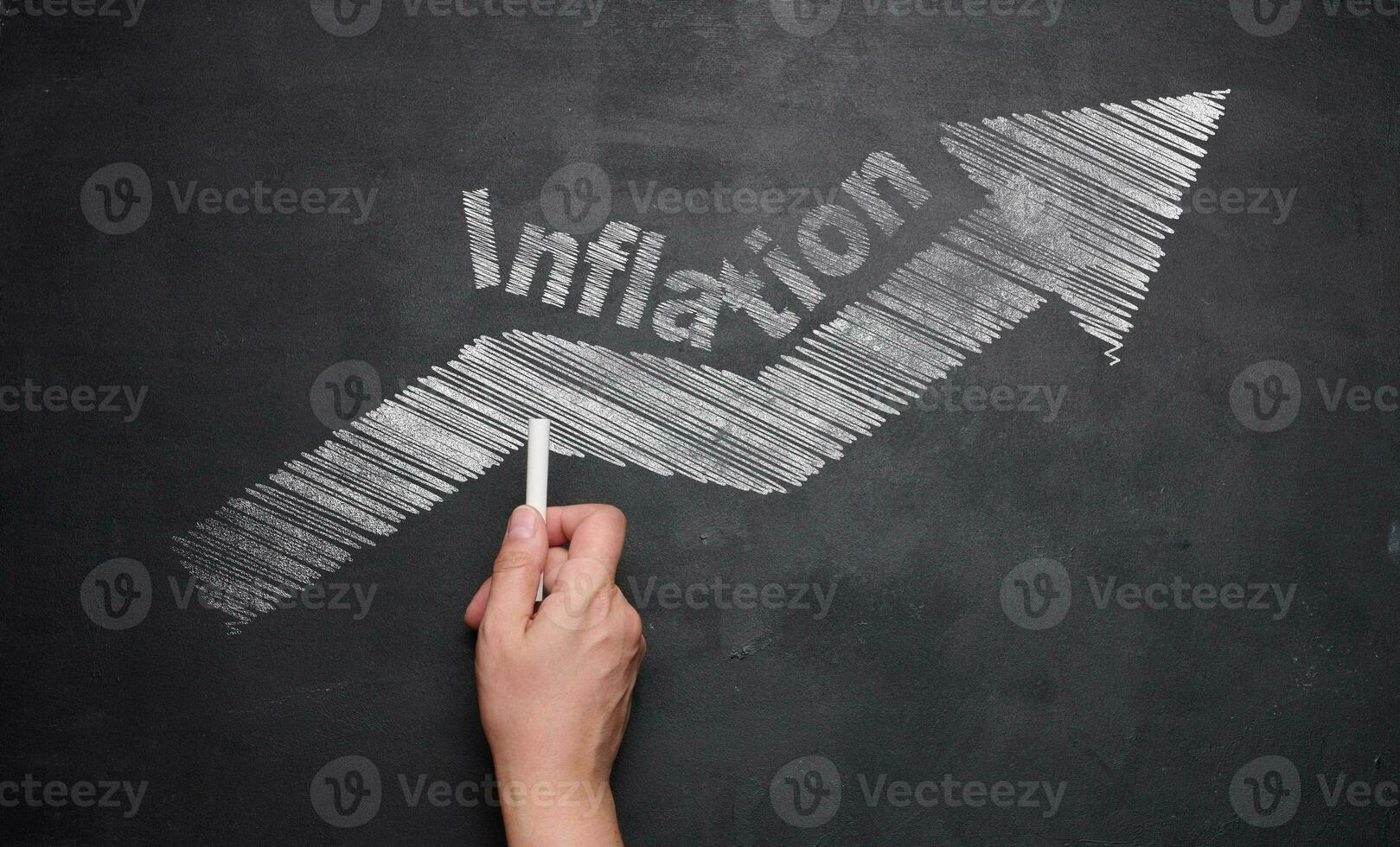 Drawn arrow with white chalk and the inscription inflation on a black chalkboard, the concept of the fall of the economy photo