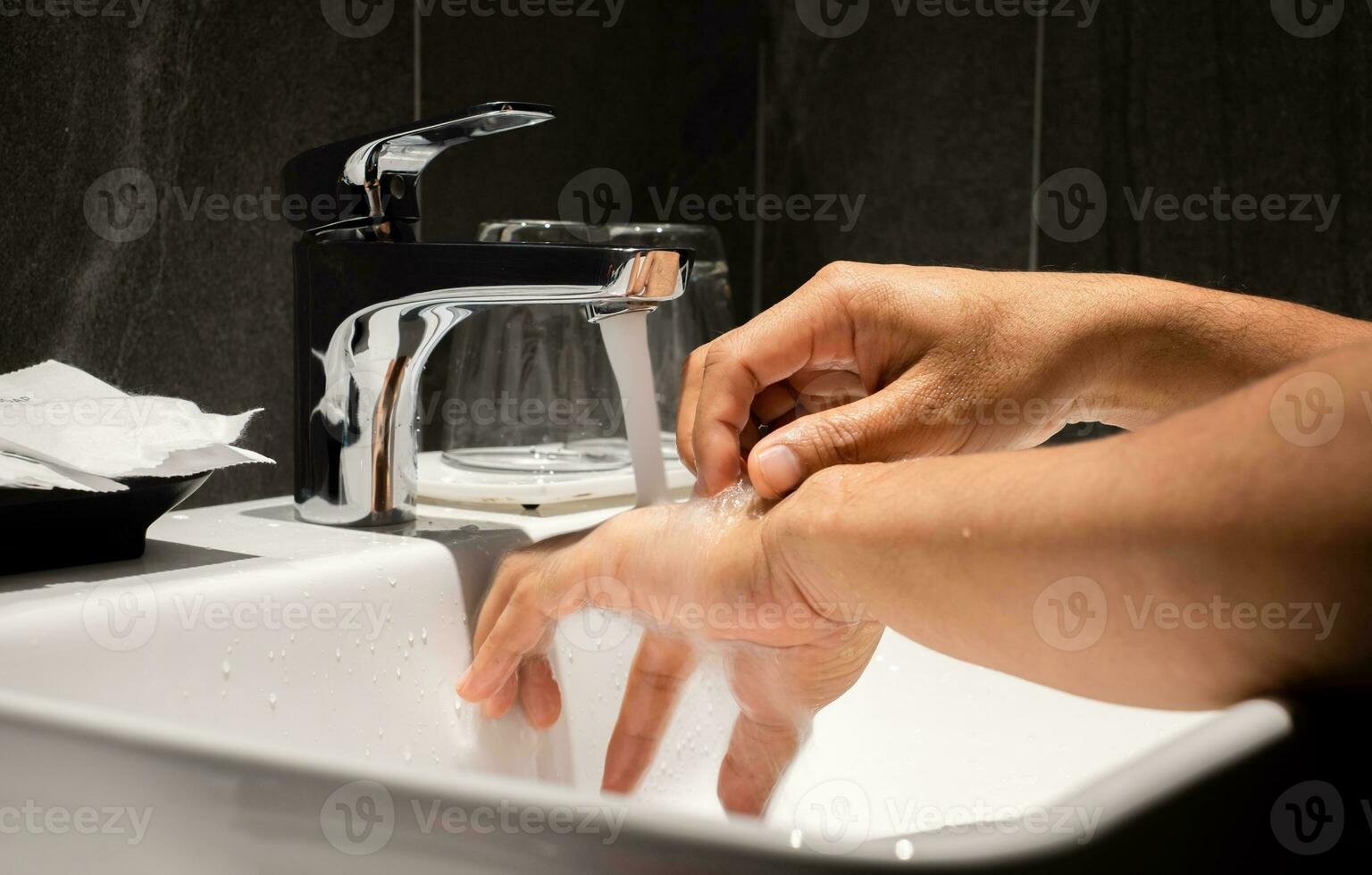 Man's hand is pouring in the sink in one of the luxury bathrooms on the property. photo