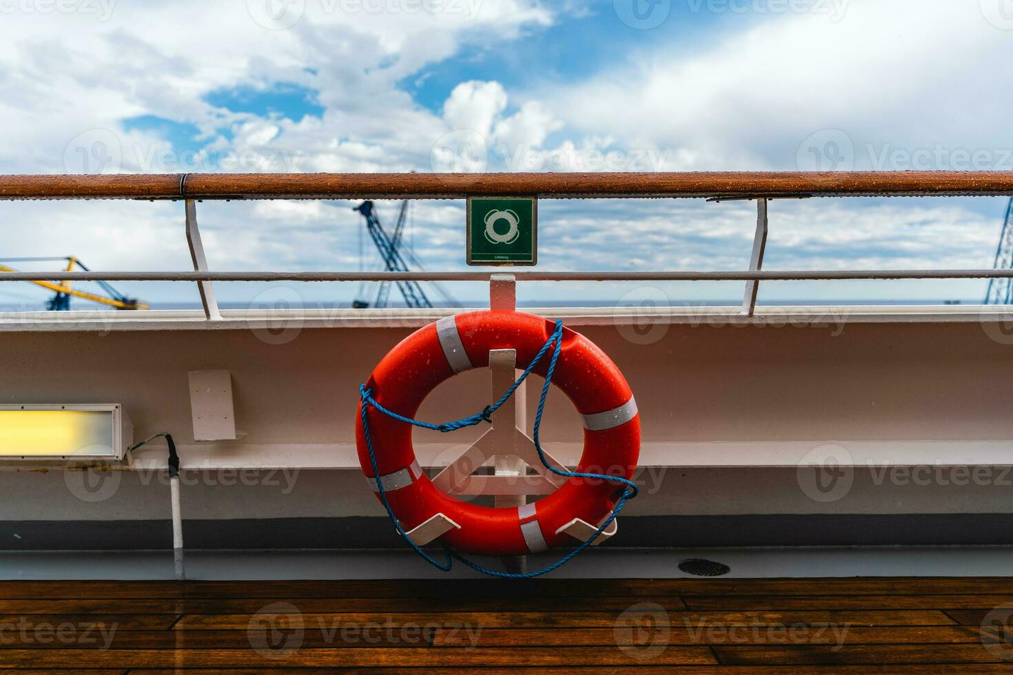 orange lifebuoy hanging from the railing of a deck on a cruise ship photo