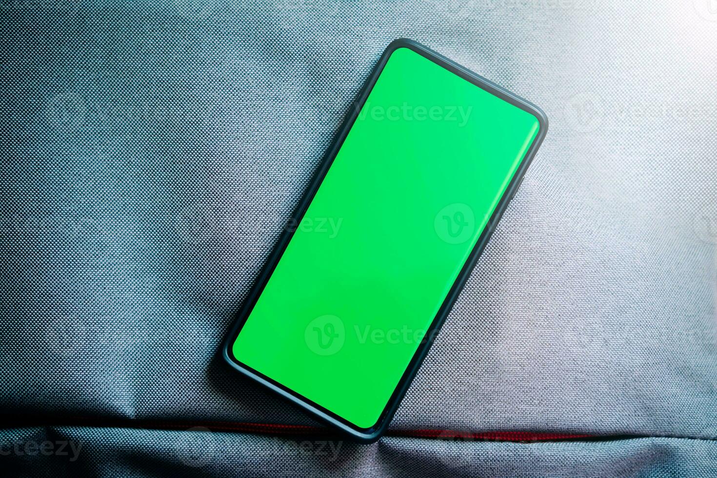Flat lay photo of smartphone green screen. Chroma key phone screen in vertical position. Photo mockup with copy space. Internet of things. New technology concept.