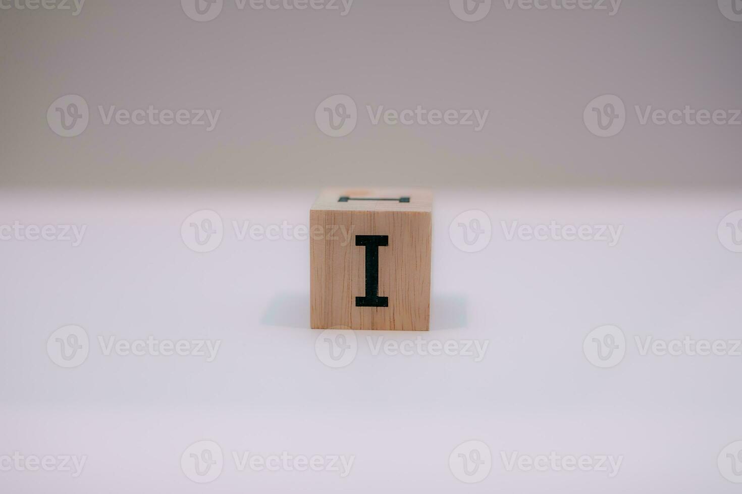 Wooden block written I with a white background, education concept, close up. photo