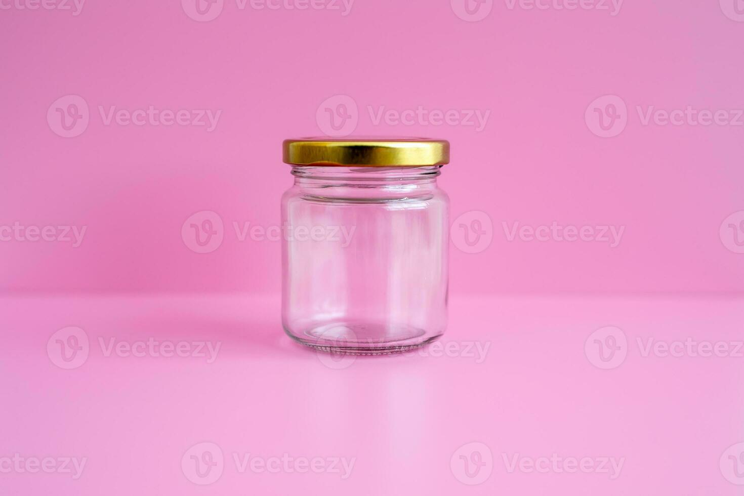 1 empty jar, gold lid, with a pink scene, close up. photo