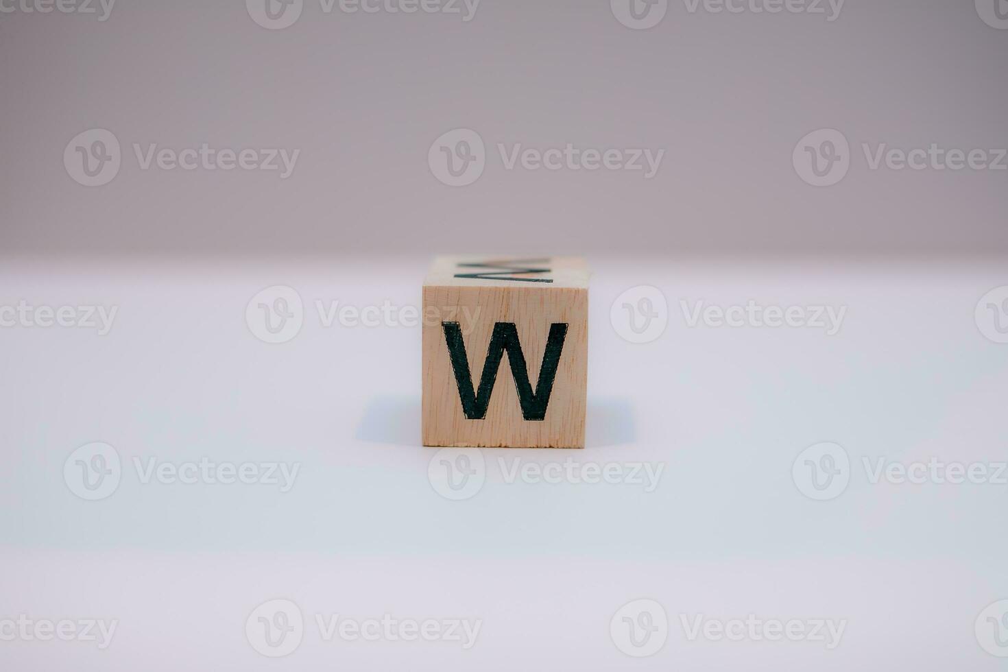 Wooden block written W with a white background, education concept, close up. photo
