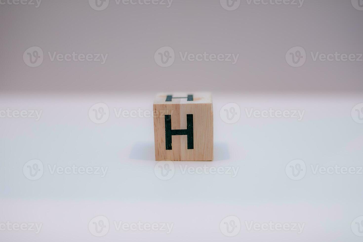 Wooden block written H with a white background, education concept, close up. photo