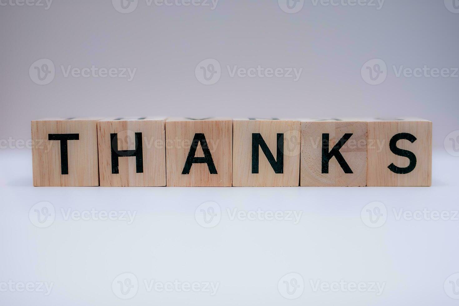 Wooden block writing message THANKS with a white background, education concept, close up. photo