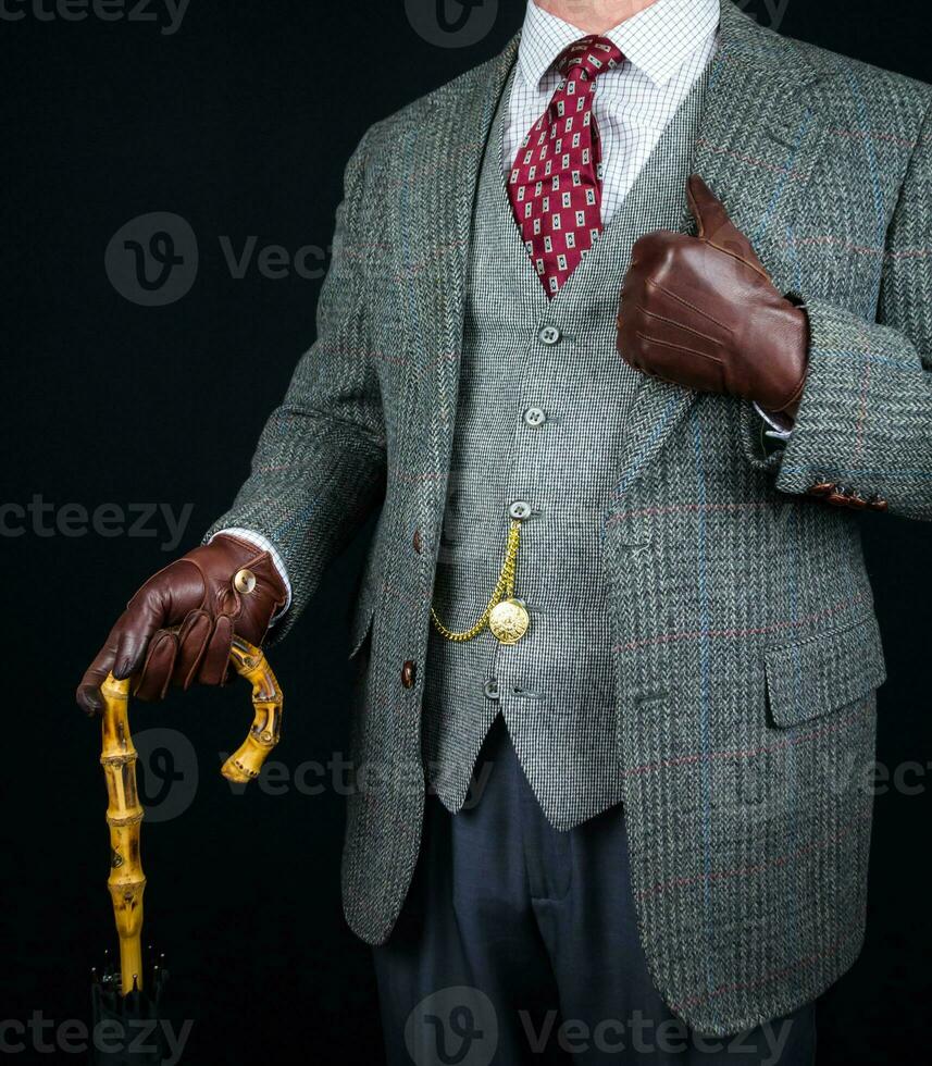 Portrait of Man in Tweed Suit and Leather Gloves Holding Umbrella. Vintage Style and Retro Fashion of Classic English Gentleman. photo