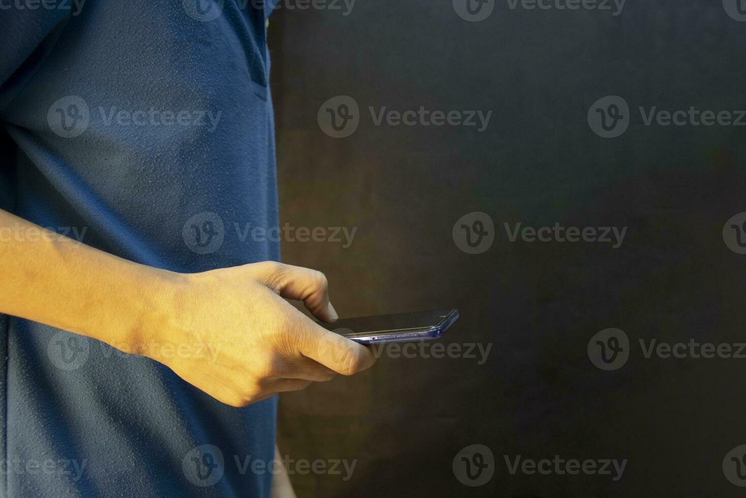 Man using smartphone against black background photo