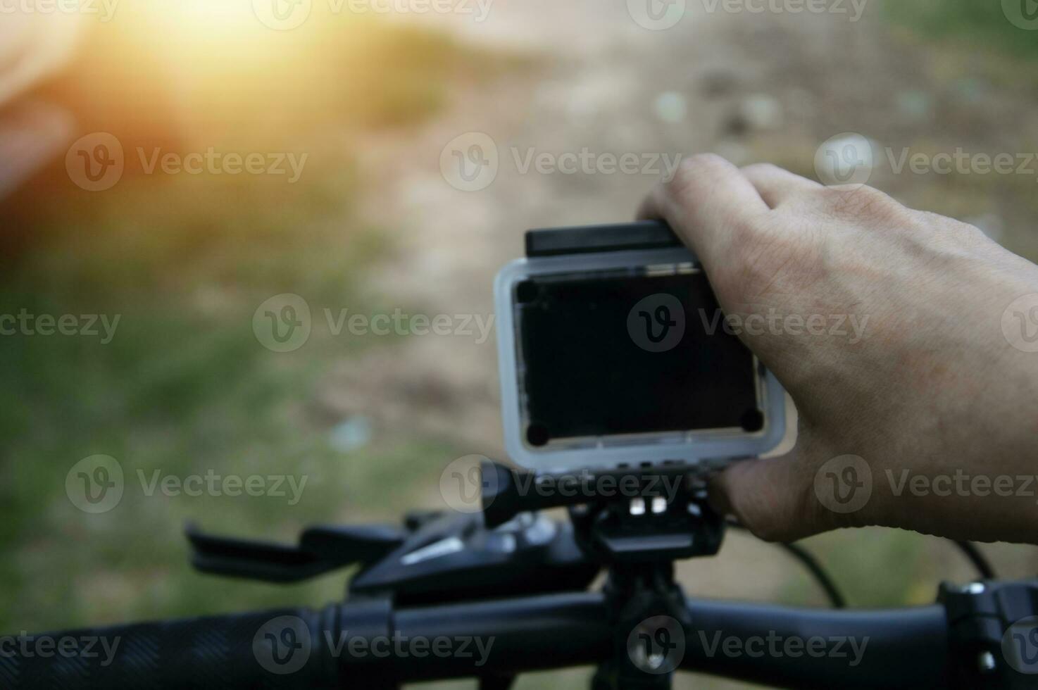 masculino mano ajustando acción cámara en bicicleta foto