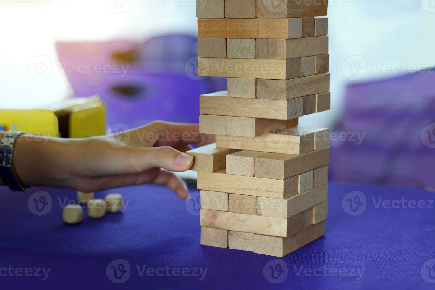 Jenga is a game in which wooden blocks are stacked up to the height of a building, then each player takes turns pulling the block one by one with one hand until the building collapses. photo