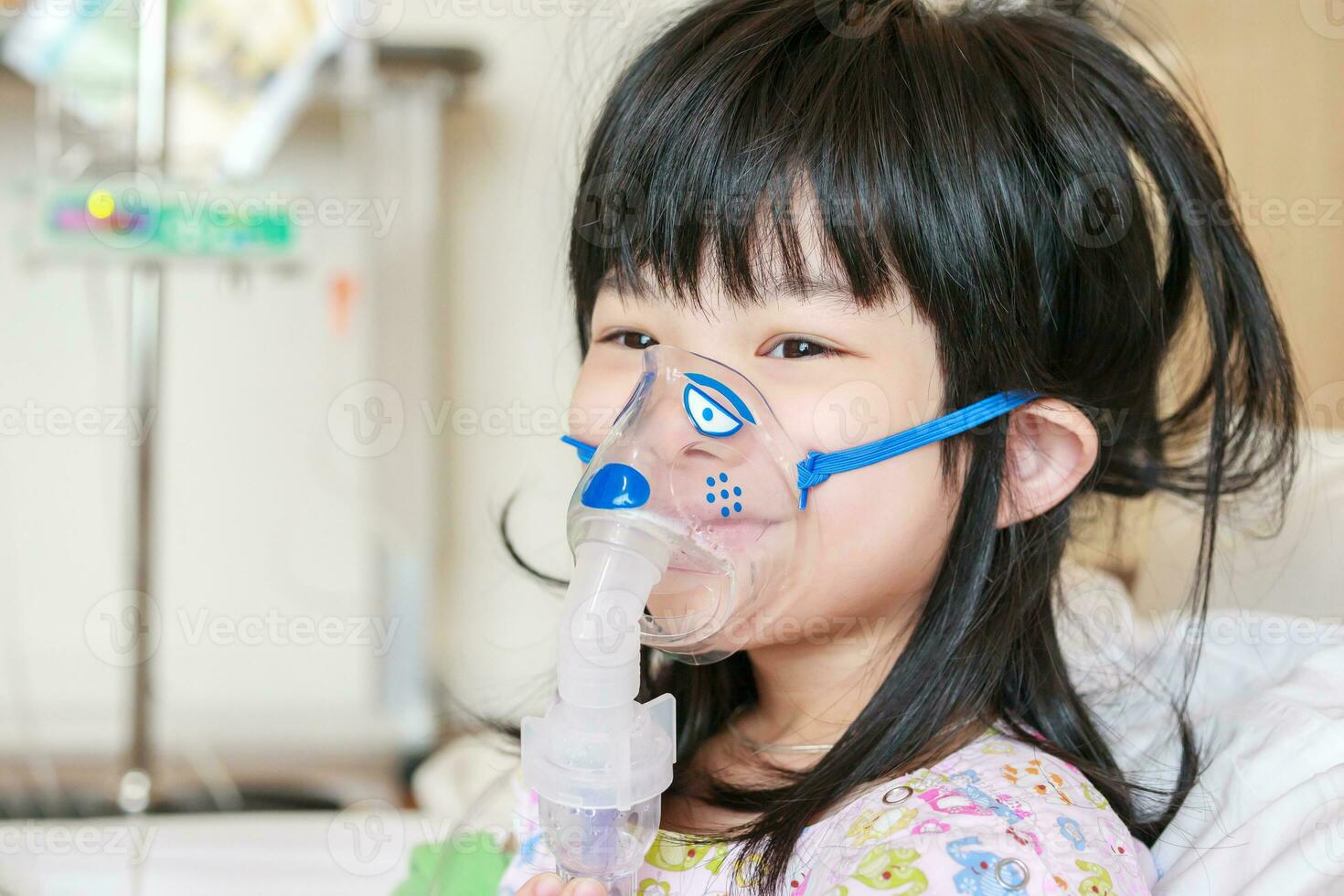 Sick little asian girl inhalation with nebulizer for respiratory treatment photo