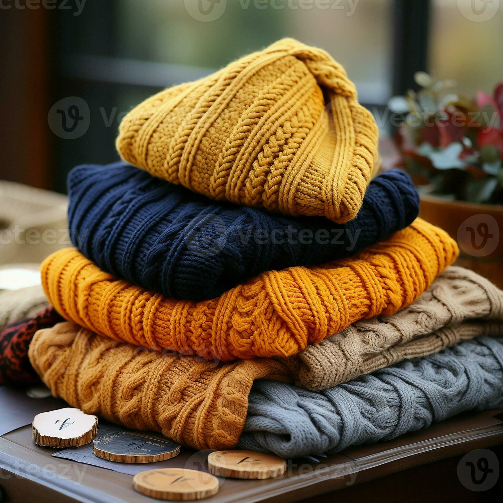 tack of knitted textured clothing on table.Colorful winter clothes