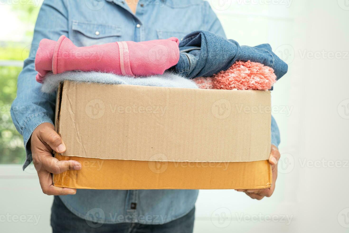 Donation box with used clothes at home to support help for poor people in the world. photo