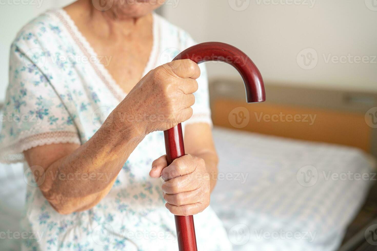 Asian elderly disability woman holding waling stick, wood cane, round handle, walking aid for help to walk. photo