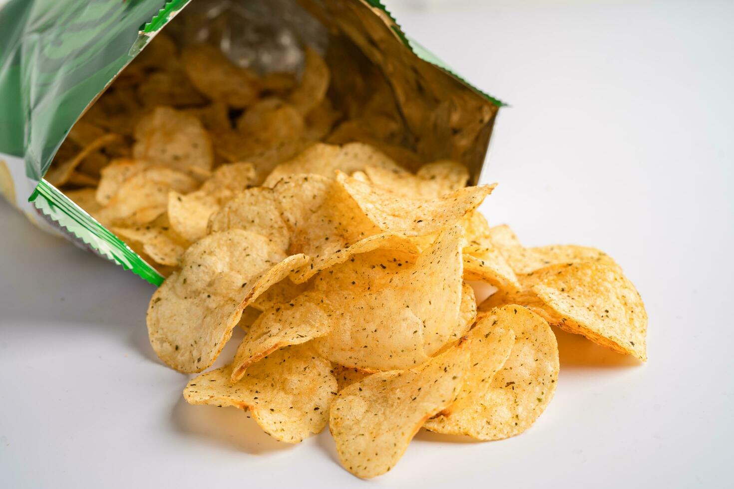 Potato chips, delicious spicy for crips, thin slice deep fried snack fast food in open bag. photo