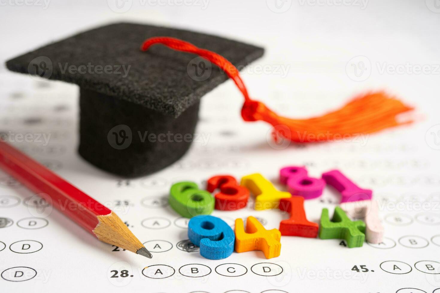 Graduation gap hat and pencil on answer sheet paper, Education study testing learning teach concept. photo