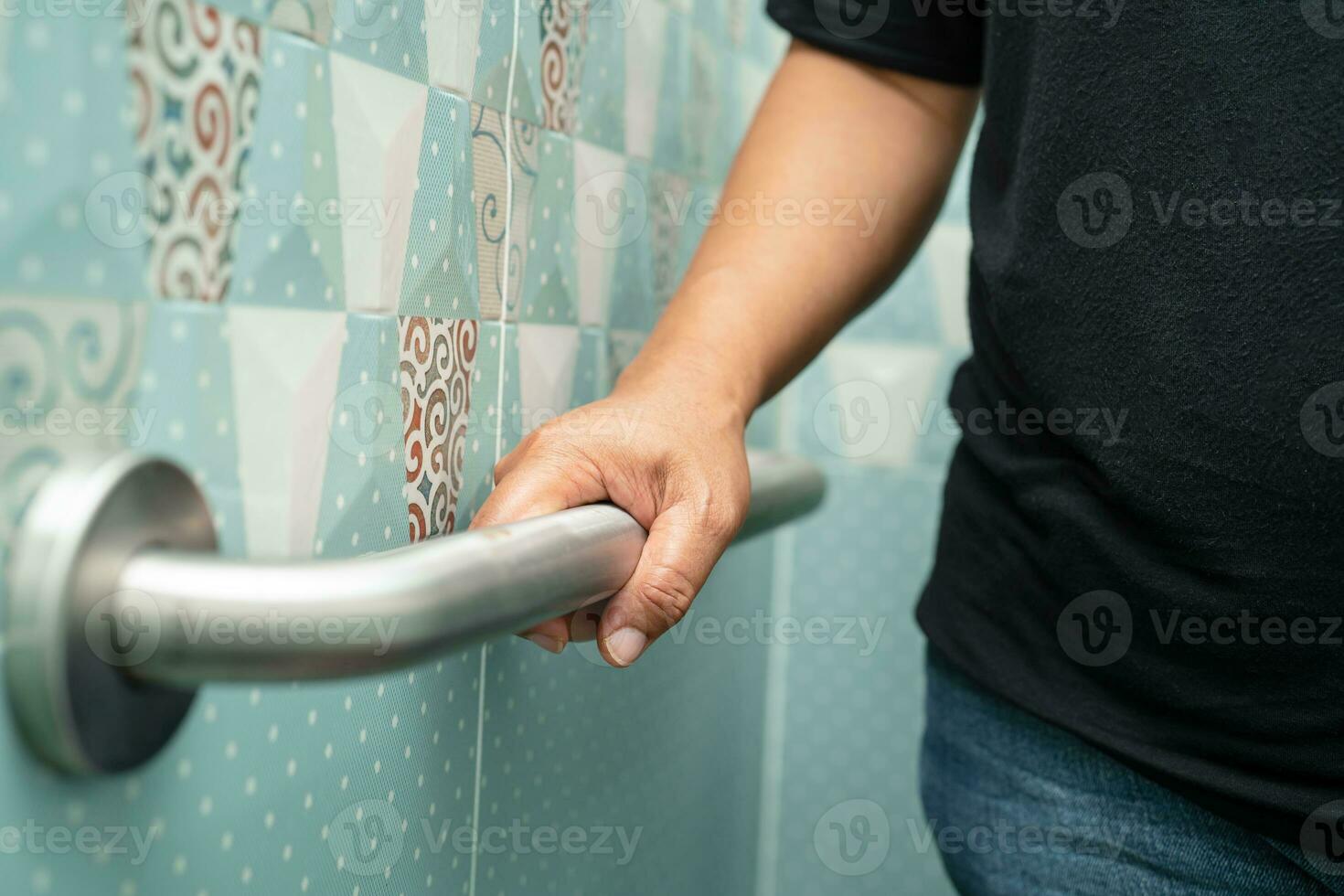 Asian elderly woman use bathroom handle security in toilet, healthy strong medical concept. photo