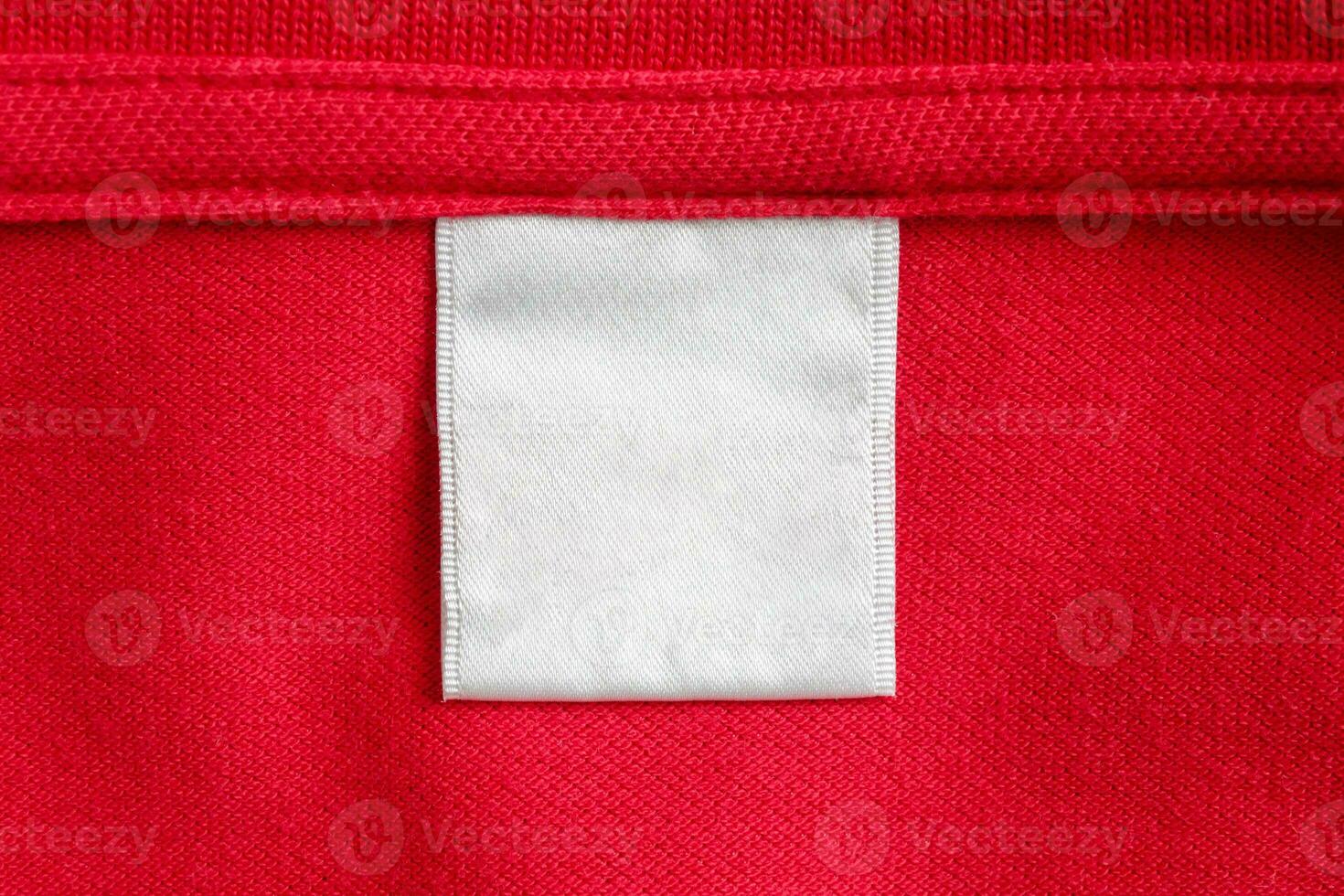 Blank white laundry care clothes label on red shirt fabric texture background photo