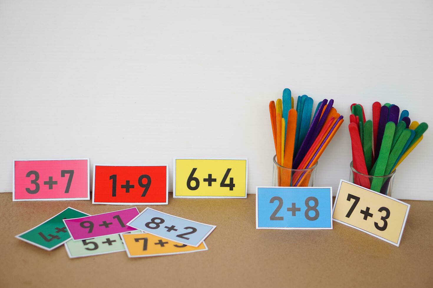 Colorful cards with numbers plus , addition on cards and colorful sticks for counting for kids. Concept, teaching aid, materials for Math subject. Education. photo