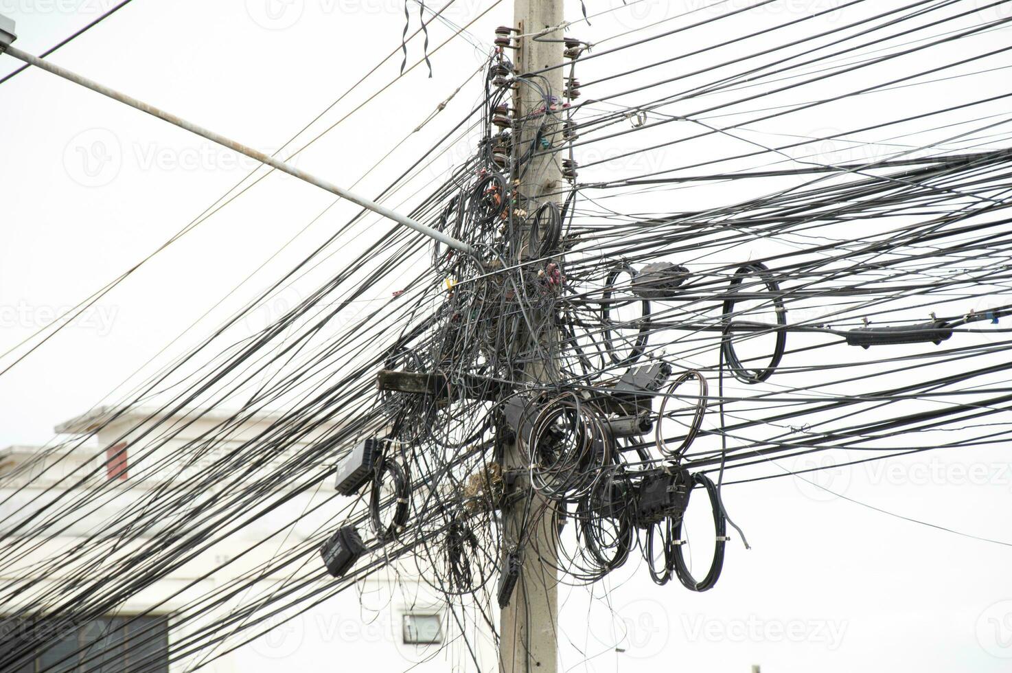 Electric wires are tangled on poles. The most common electrical cable in Thailand. photo