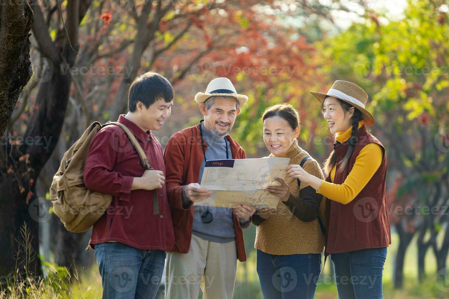 Happy Asian family with senior parent are walking together in public park during autumn with maple and ginkgo tree while looking at map for fall color travel destination and family happy vacation photo