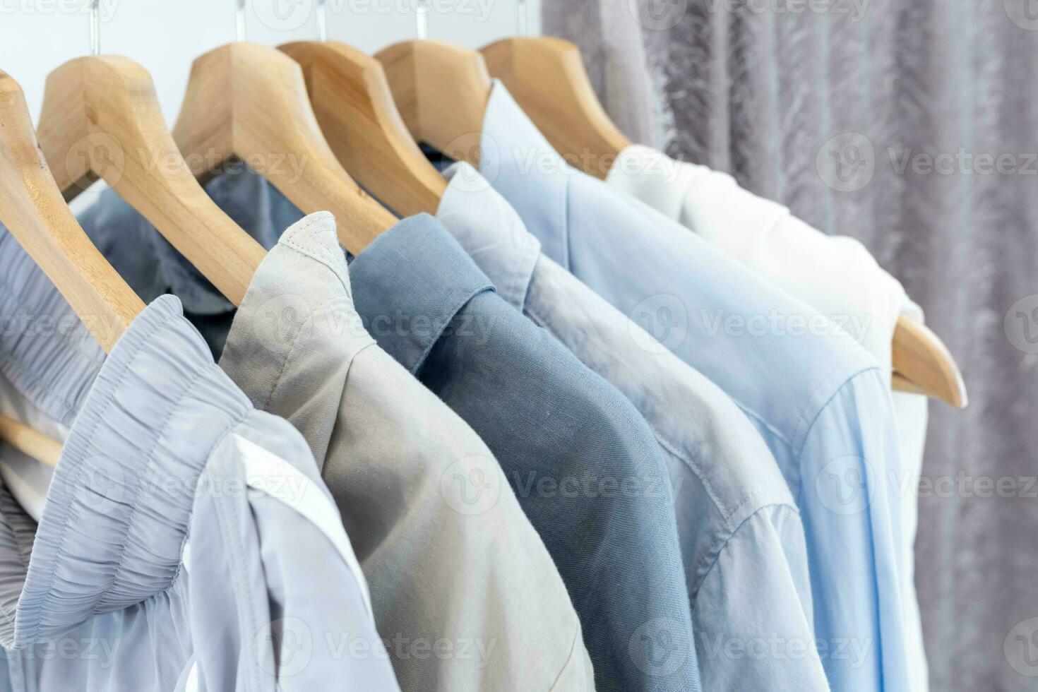 Rack of blue and grey tone cotton shirts on the open closet at second hand retail shop for eco friendly textile product and organic natural dyed beach color photo