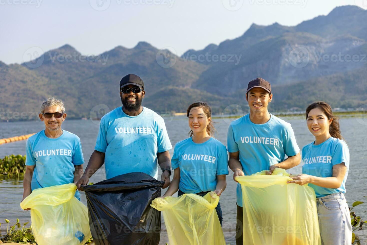 Team of young and diversity volunteer worker group enjoy charitable social work outdoor in cleaning up garbage and waste separation project at the river beach photo