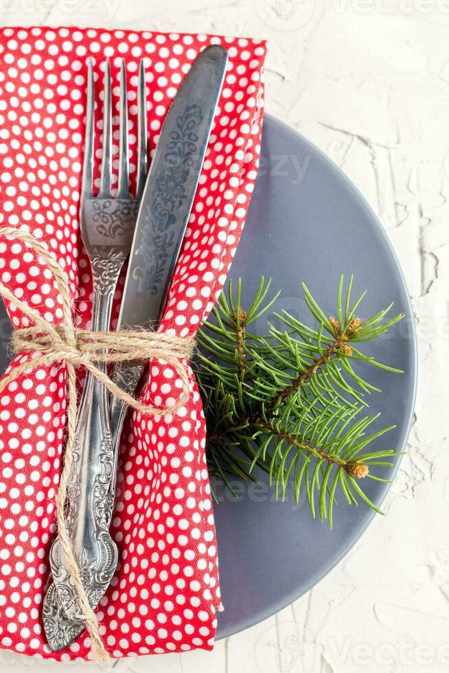 Christmas menu background with fork knife napkin and fir tree brunch on white table. top view photo