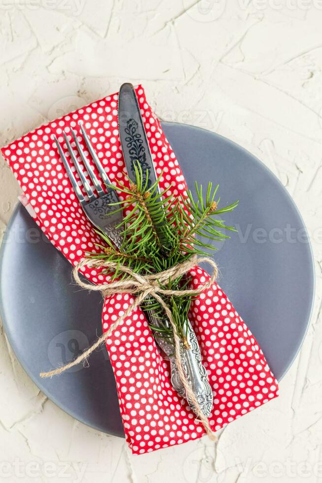 Christmas menu background with fork knife napkin and fir tree brunch on white table. top view photo