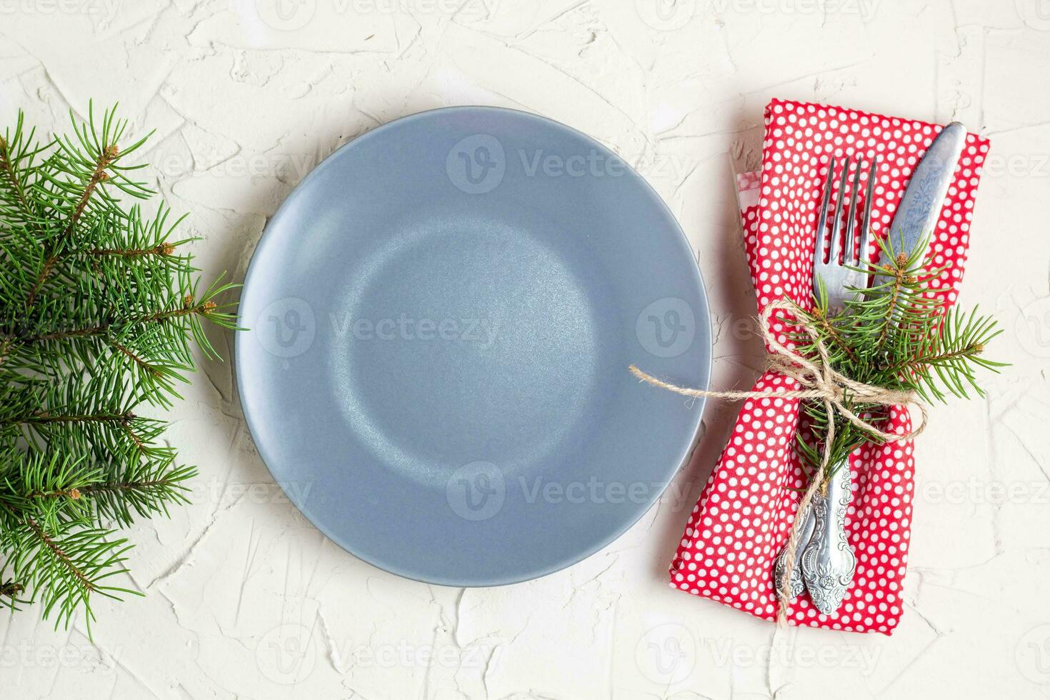 Christmas menu background with fork knife napkin and fir tree brunch on white table. top view photo