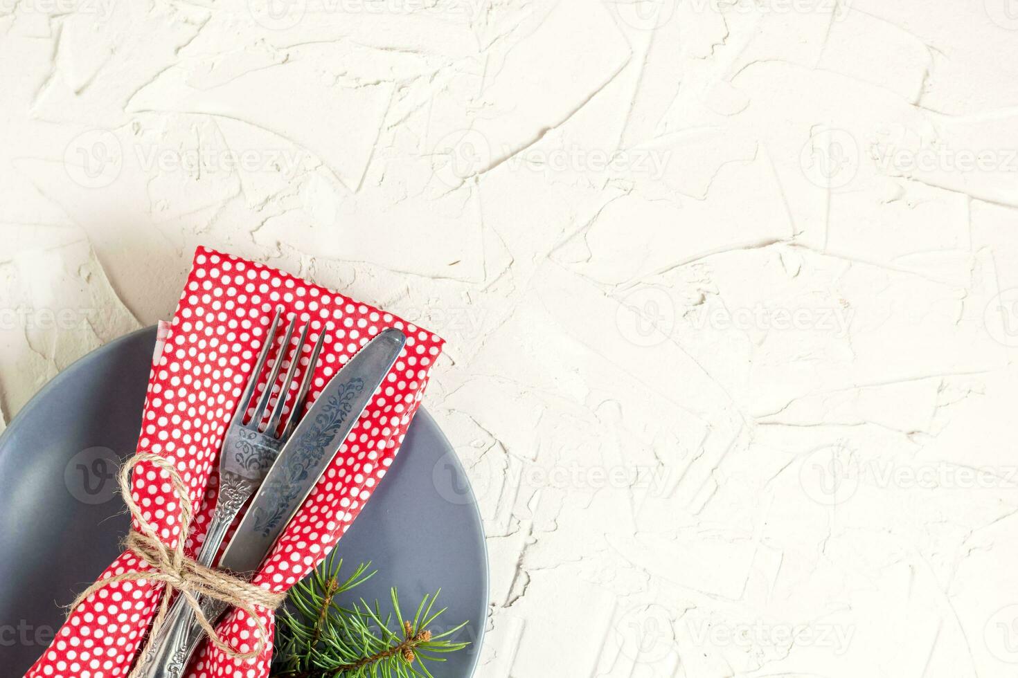 Christmas menu background with fork knife napkin and fir tree brunch on white table. Copy space, top view photo