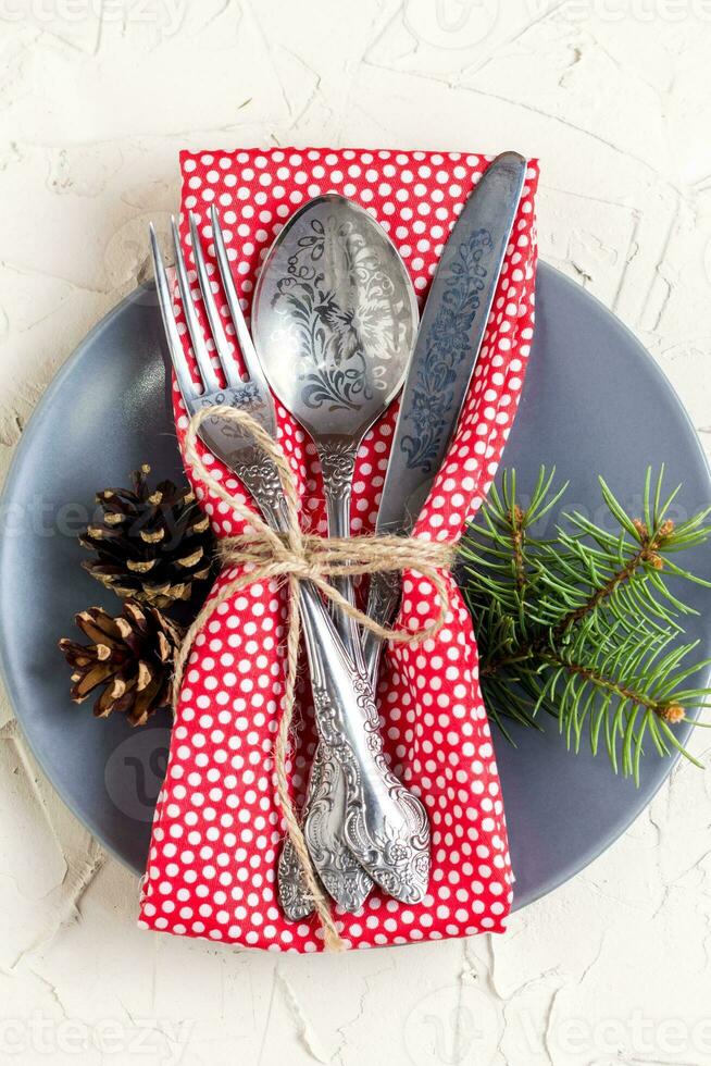 Christmas menu background with fork knife napkin and fir tree brunch on white table. top view photo