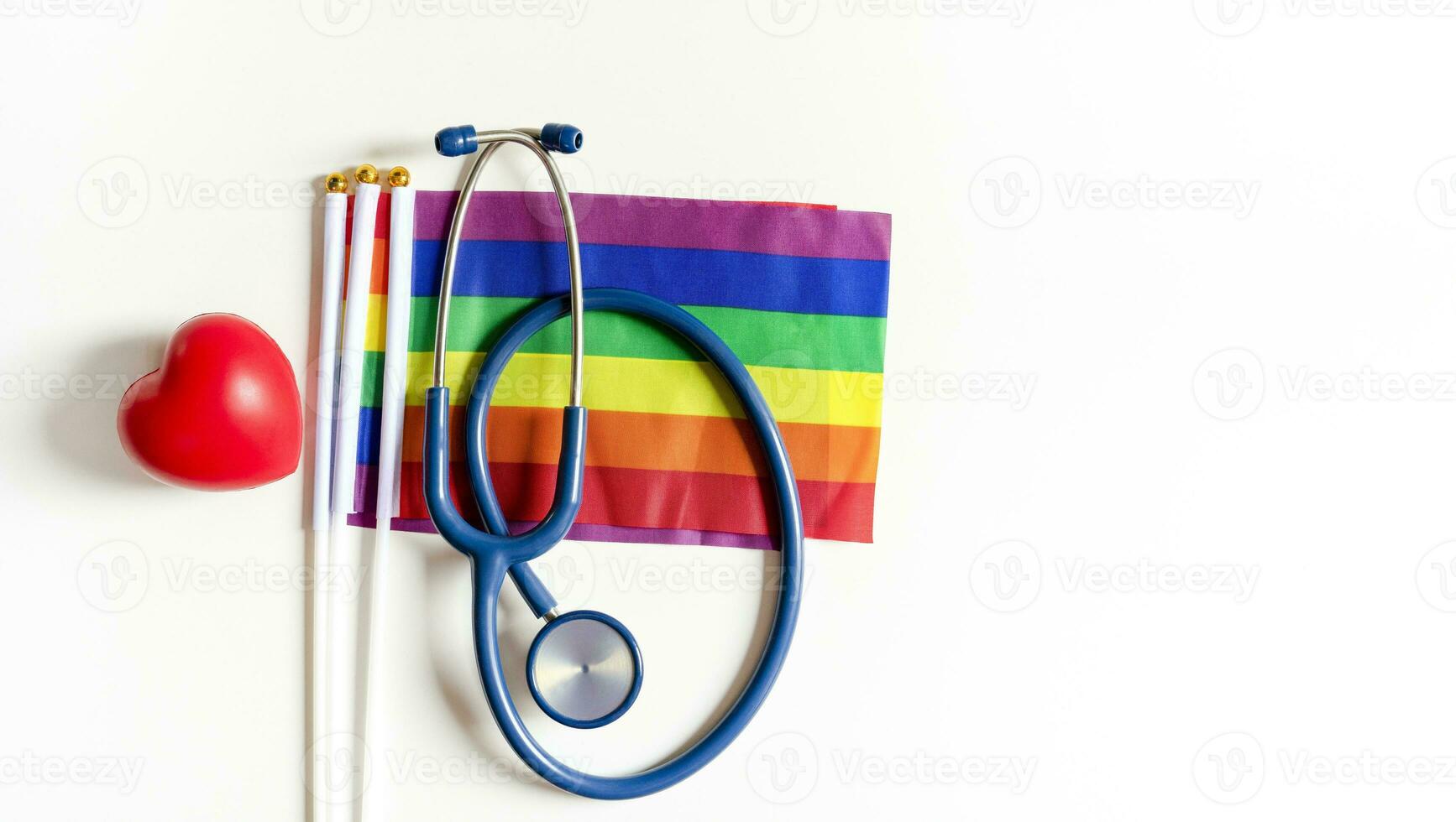 stethoscope on lgbtq rainbow flags pride symbol and red heart isolated on white background with copy space photo