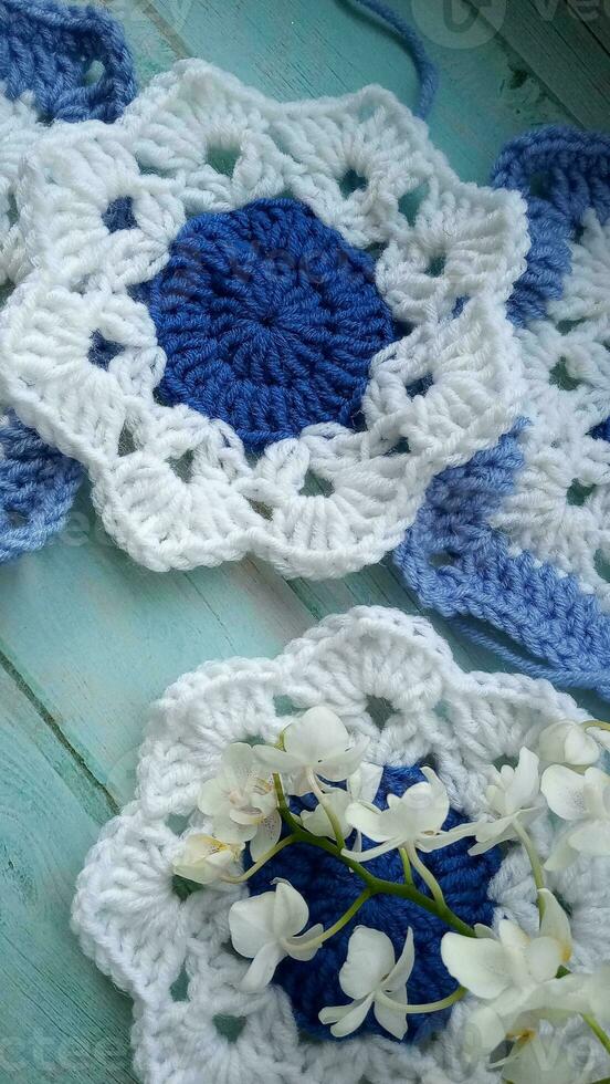 Blue, white crochet elements and orchid. Crochet texture, place for an inscription, adapted for mobile phone photo