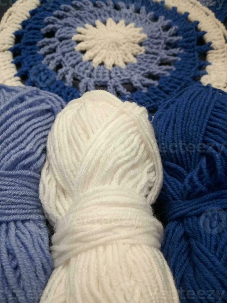 Blue, white round crochet elements and balls of yarn. Crochet texture, place for an inscription, adapted for mobile phone photo