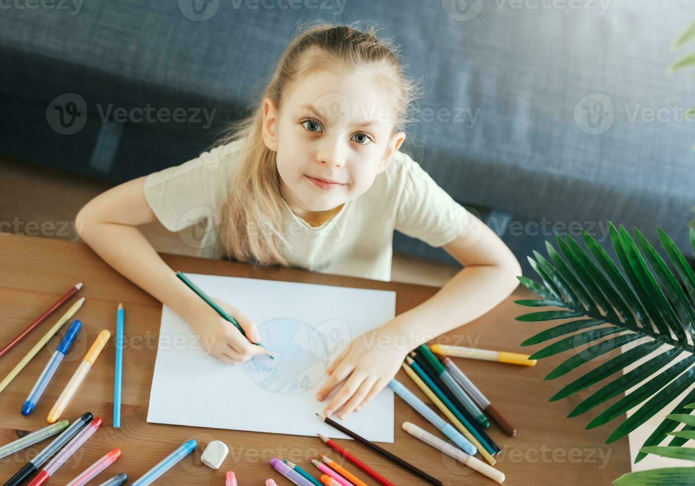 Child girl drawing with colorful pencils photo