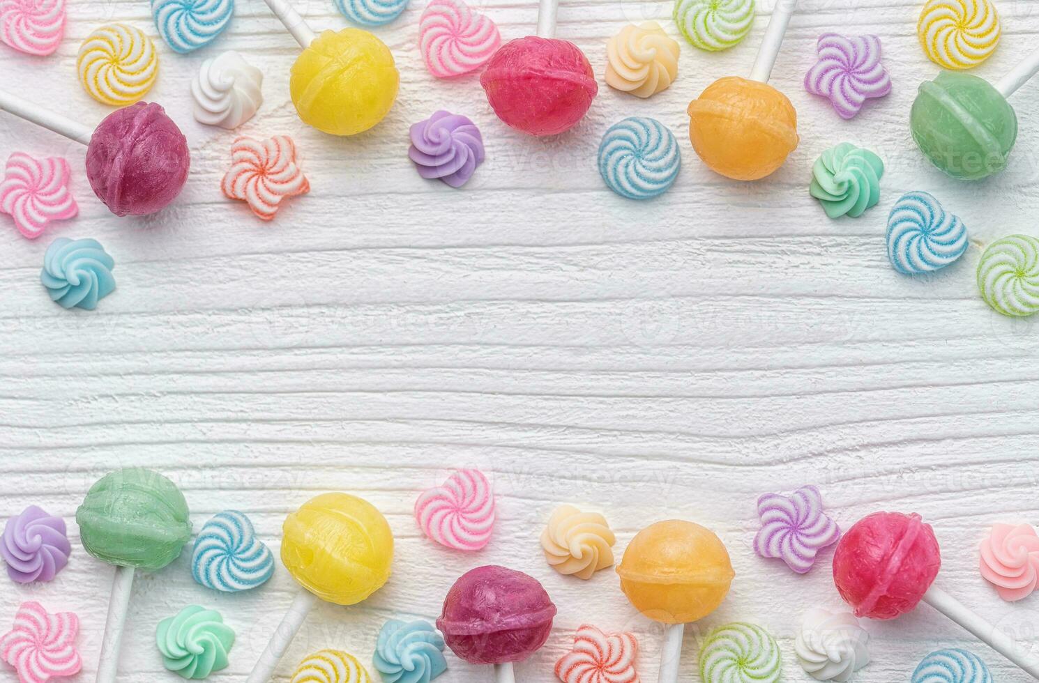 Sweet lollipops and candies on white wooden background photo