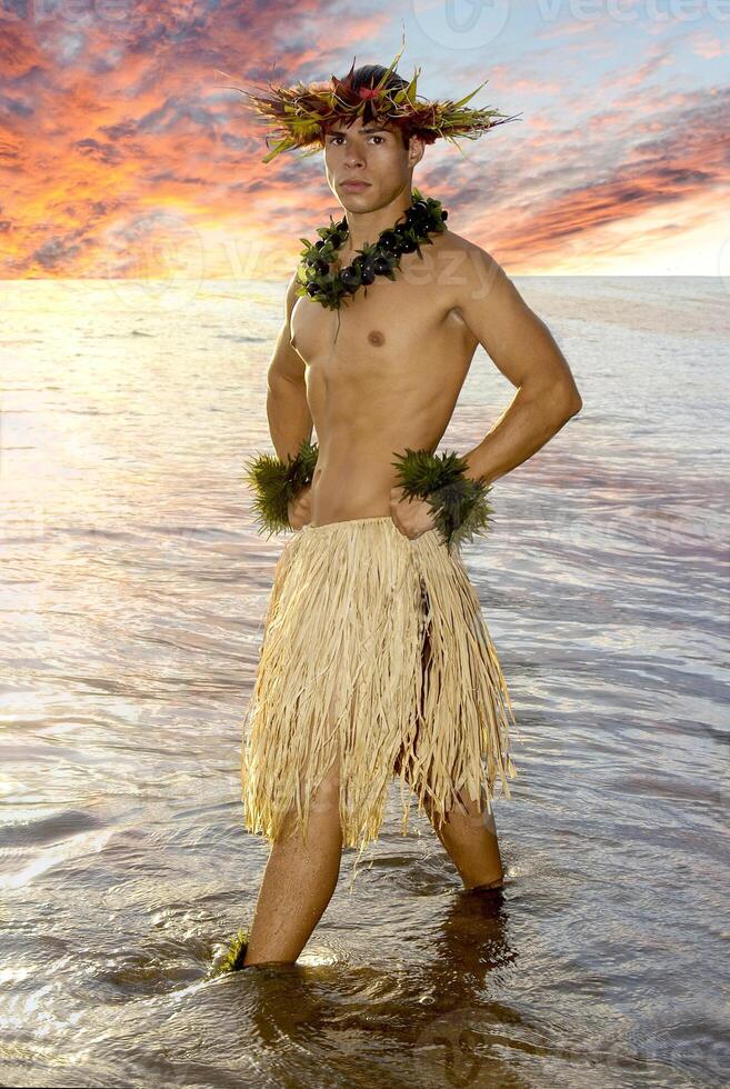 NOT - A male hula dancer strikes a sunset pose on the oceans edge in the water. photo