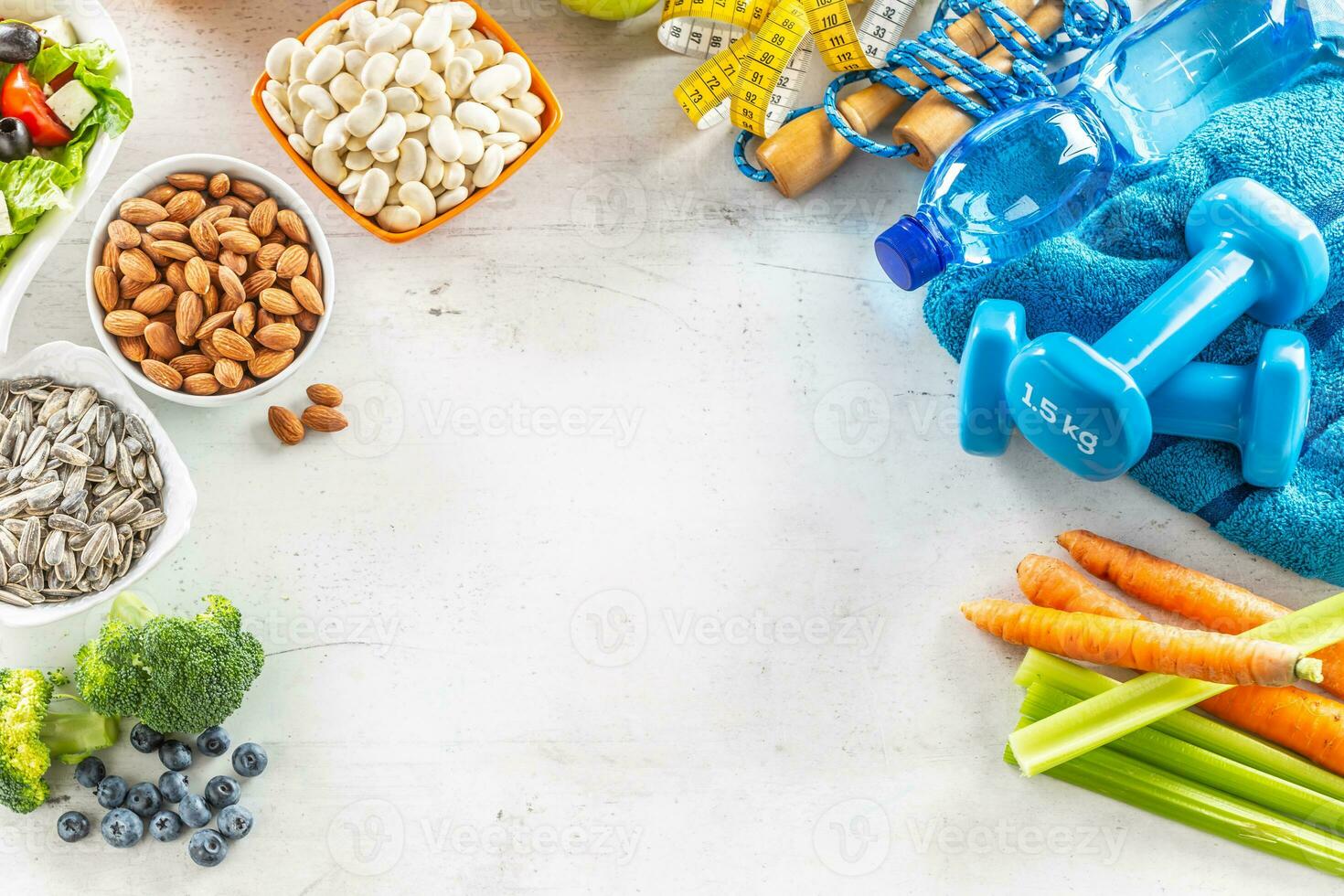 Selection of healthy foods, vegetables, fruits, almonds, salad, exercise tools and measuring tape photo