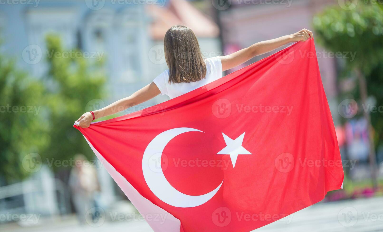 Happy girl tourist walking in the street with turkey flag photo