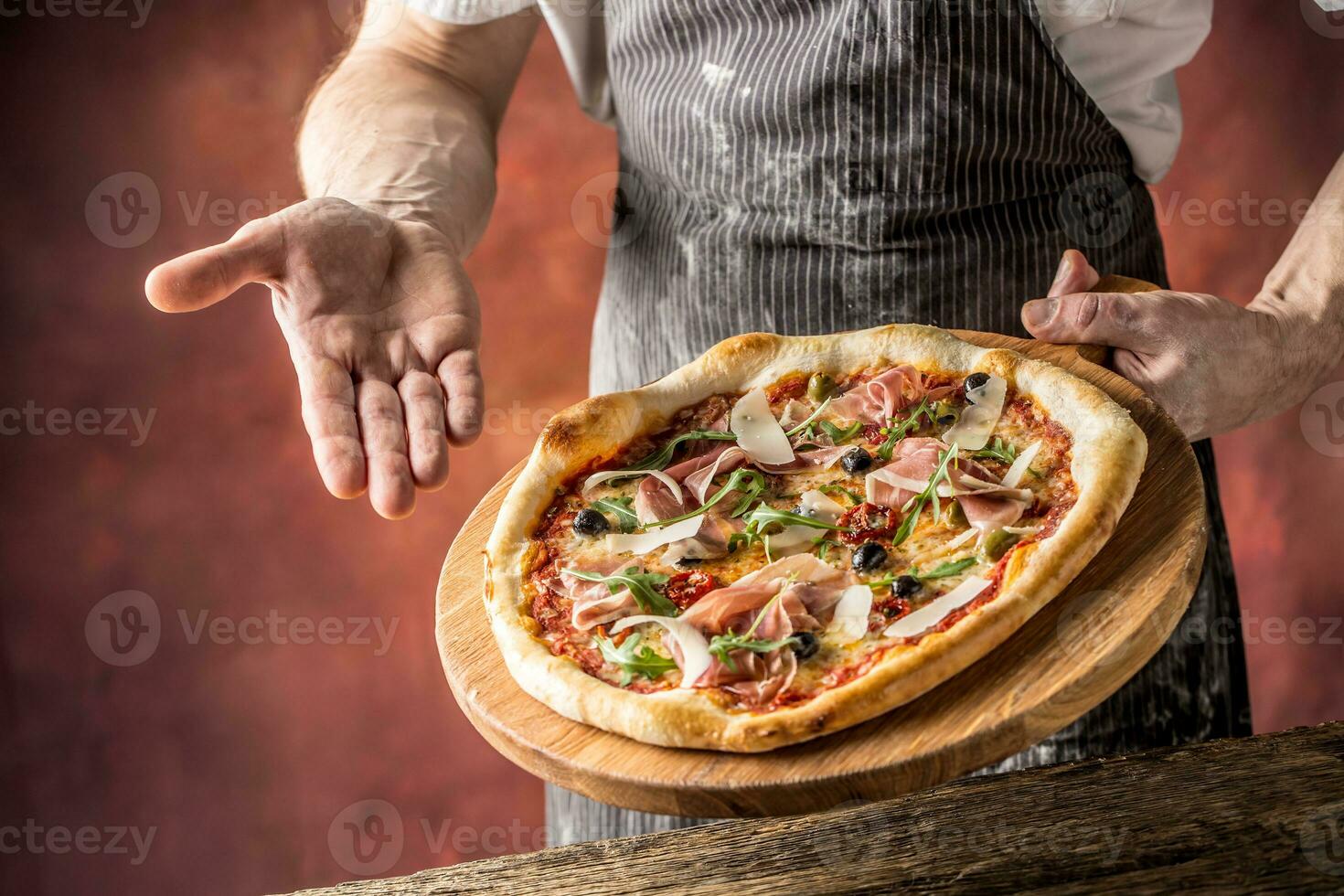 cocinero y Pizza. cocinero ofrecimiento Pizza en hotel o restaurante foto